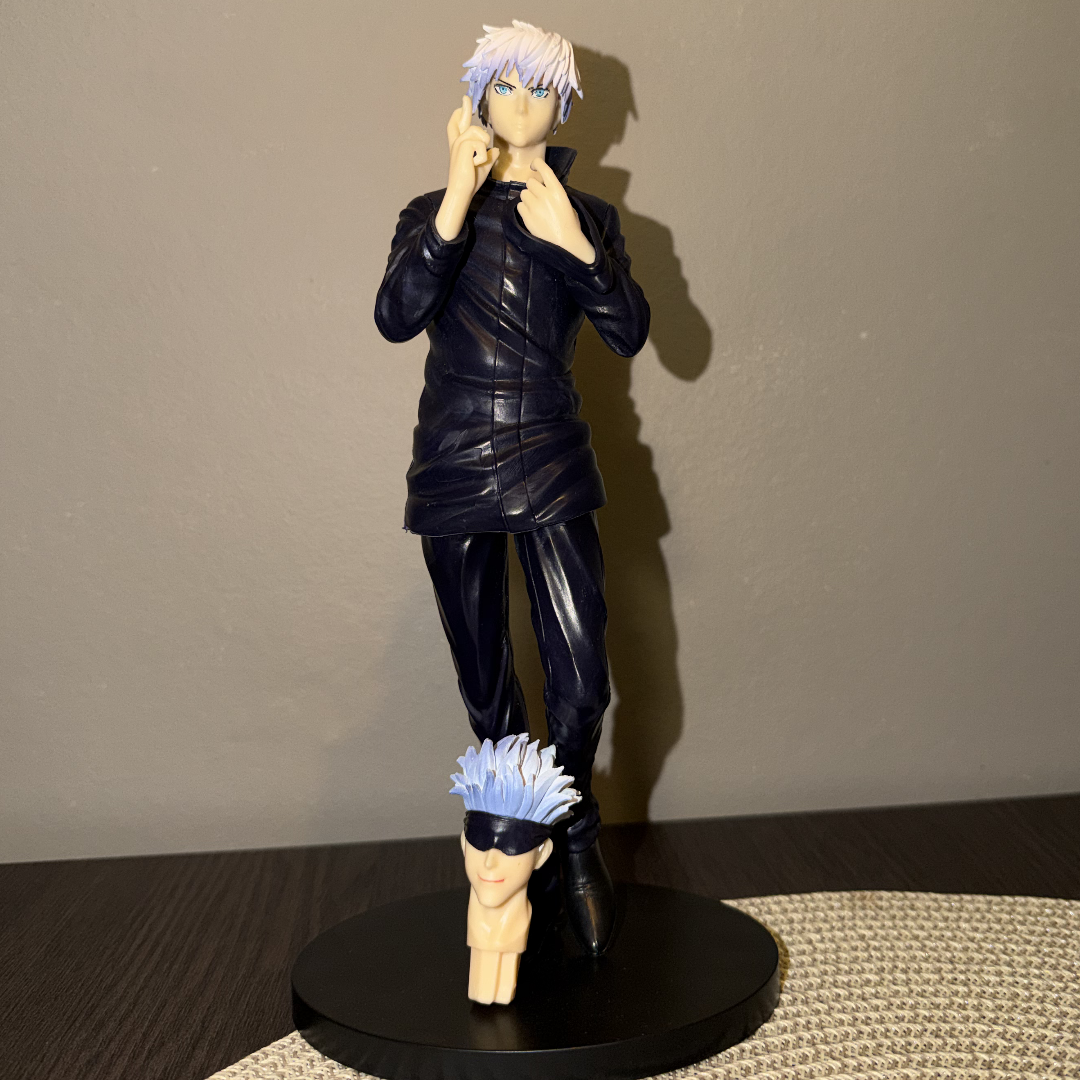 Action figure with a black outfit and blue hair on a stand against a plain background